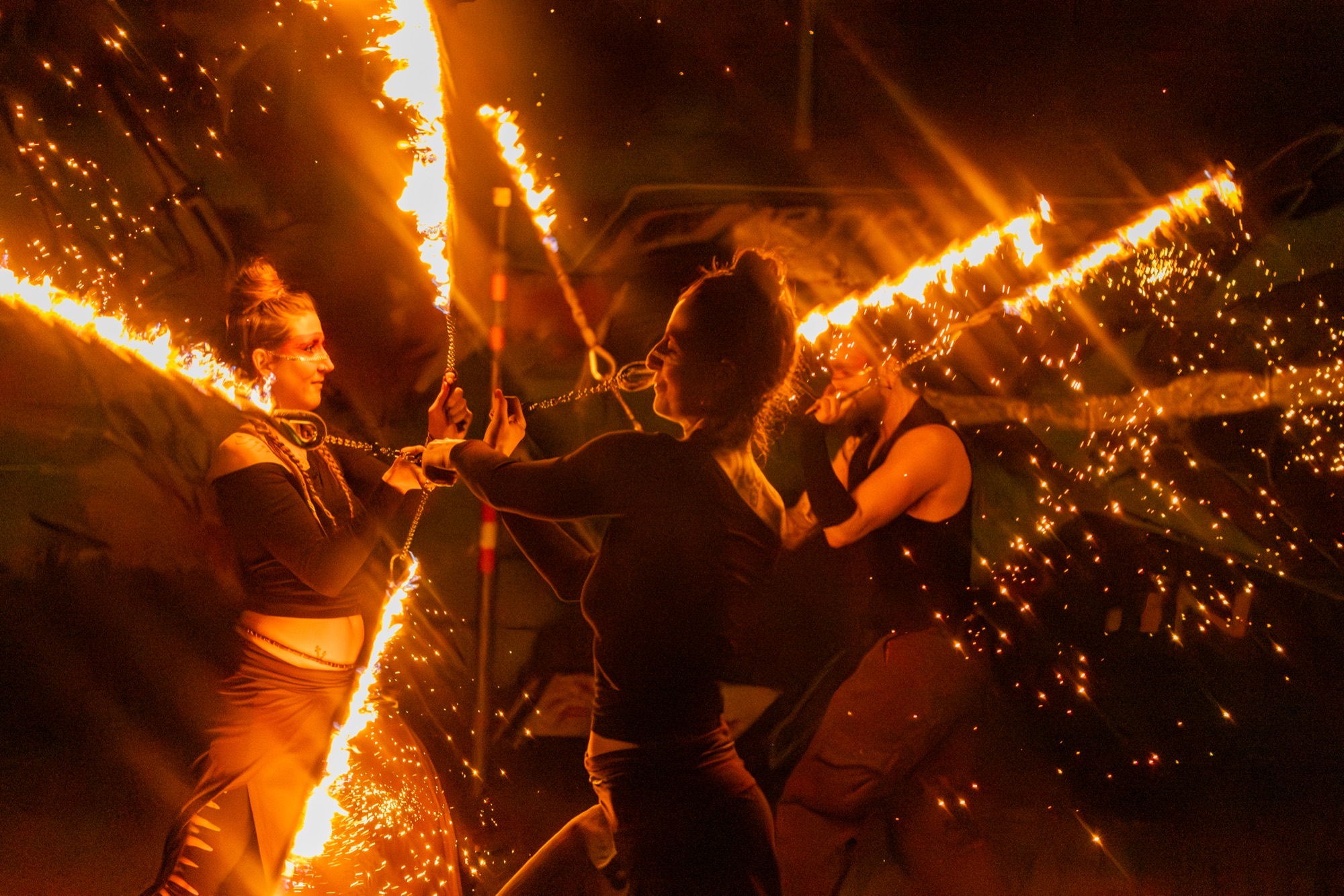 Fire performers with sparking staffs, showers of sparks in the night